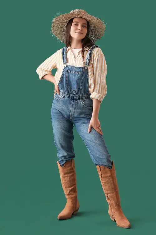A woman wears jeans with stripped shirt and brown cowboy boots