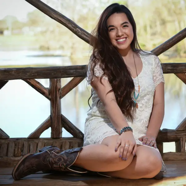 A woman wears lace dress with cowboy boots