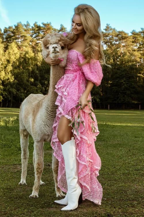a woman wears white cowboy boots with a pink long dress