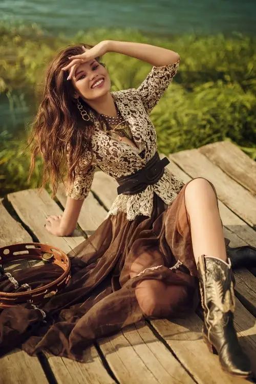 a woman wears black cowboy boots with brown long sheer dress