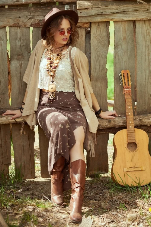 a woman wears brown cowboy boots with a brown skirt and lace top in the summer
