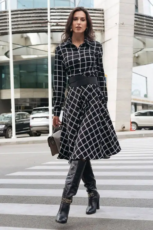 a woman wears cowboy boots with a long black dress