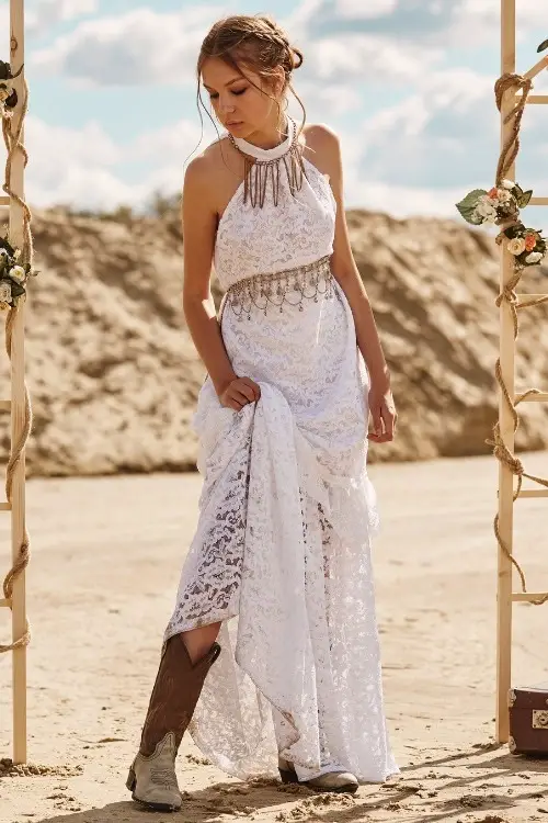 a woman wears cowboy boots with long white lace dress