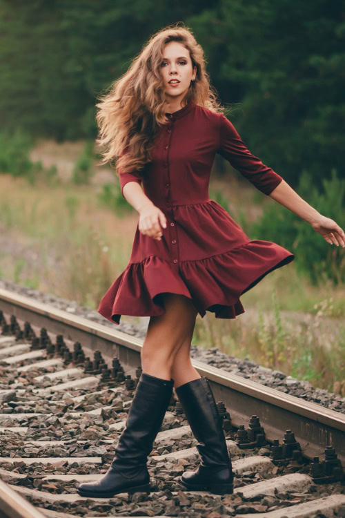 a woman wears red dress with black cowboy boots