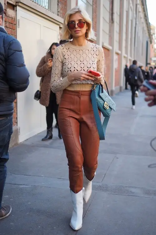 a woman wears white cowboy boots with brown pants