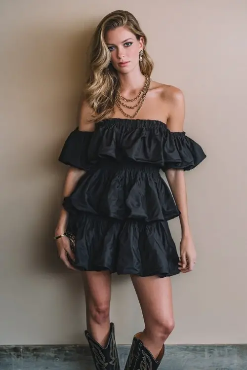 a woman in a dramatic black ruffled off-shoulder dress with cowboy boots at a birthday celebration