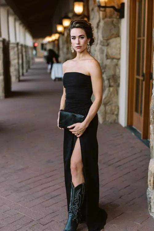 a woman in a long black gown with a side slit and cowboy boots at an evening wedding reception