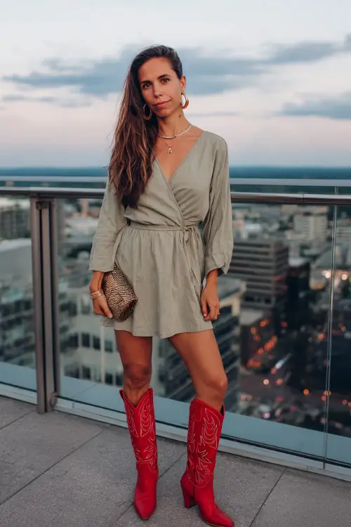 A woman over 30 wears a lightweight wrap dress paired with striking red cowboy boots, oversized hoop earrings and a sleek clutch