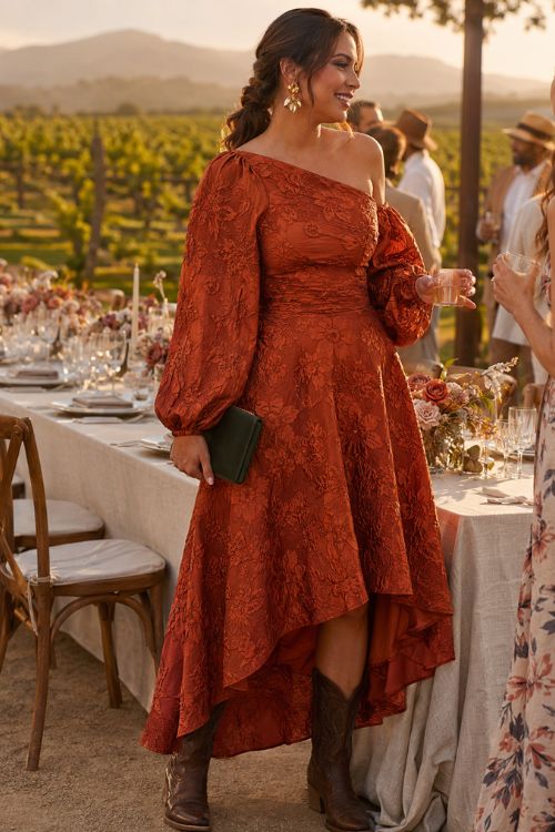 a woman in a rust wedding guest dress with puff sleeve, with brown cowboy boots