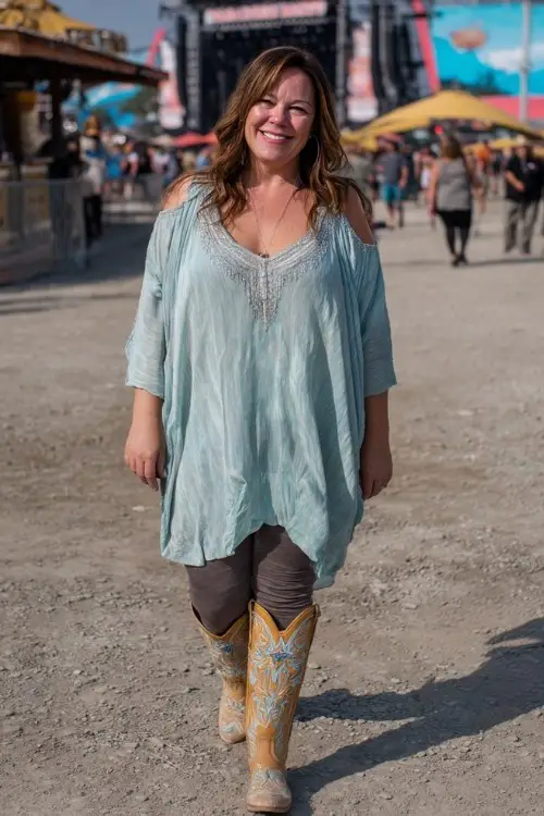 A plus-size woman over 40 wears a flowy tunic with leggings and embellished cowboy boots