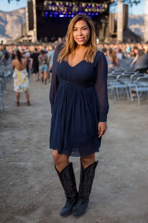 A plus size woman wears a navy chiffon midi dress with long sleeves and tall black cowboy boots (5)