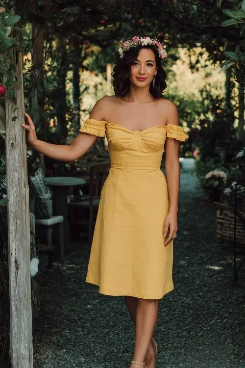 A woman in a cheerful yellow off-the-shoulder knee-length dress with flutter sleeves and a delicate flower crown
