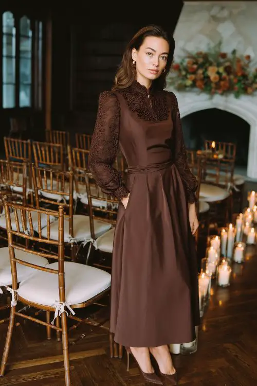 A woman wears a chocolate brown A-line dress with lace sleeves and a defined waistline