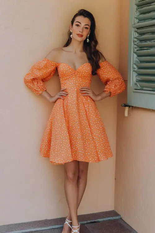 Short orange dress with subtle ivory polka dot pattern, sweetheart neckline, puff sleeves, fit-and-flare silhouette