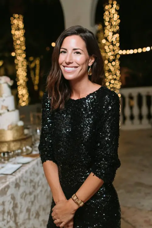 a woman in a black sequin cocktail dress with three-quarter sleeves and fitted silhouette