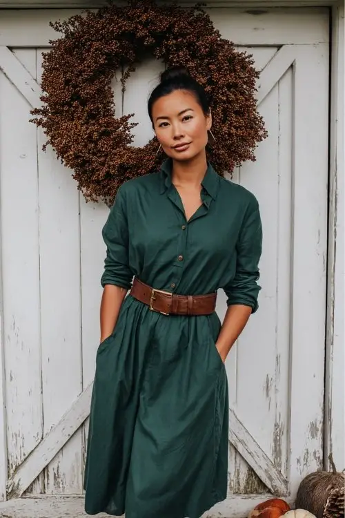 a woman in a forest green shirt dress cinched with a leather belt