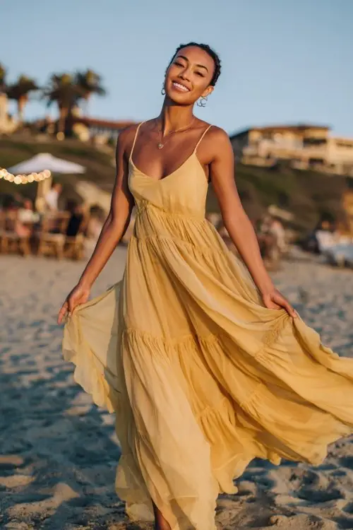a woman in a goldenrod chiffon tiered gown with thin straps