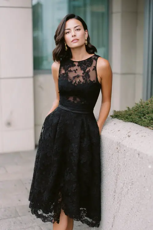 a woman over 30 in a black lace tea-length dress with satin underlay and illusion neckline