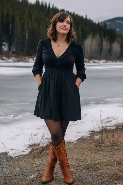 A curvy woman wears a black A-line dress with ruffled cuffs, opaque tights, and brown cowboy boots