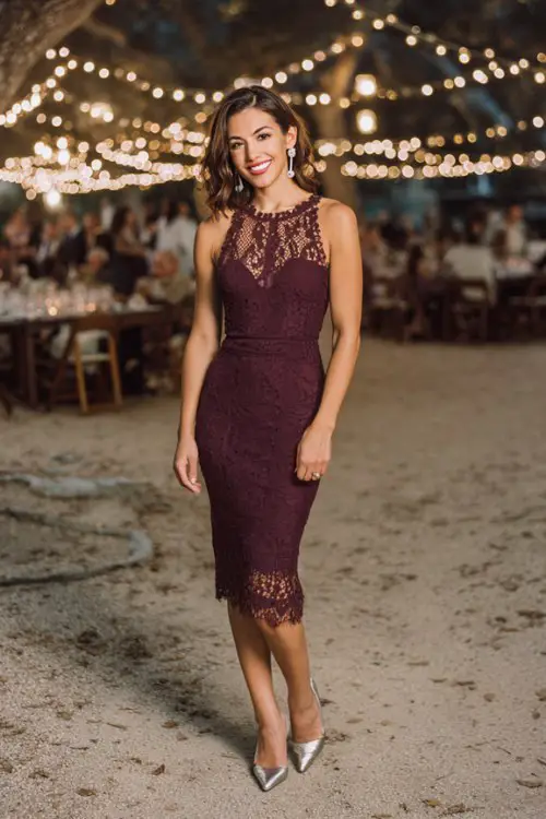 A petite woman wears a plum-colored sheath dress with delicate lace overlay and scalloped hem just below the knee
