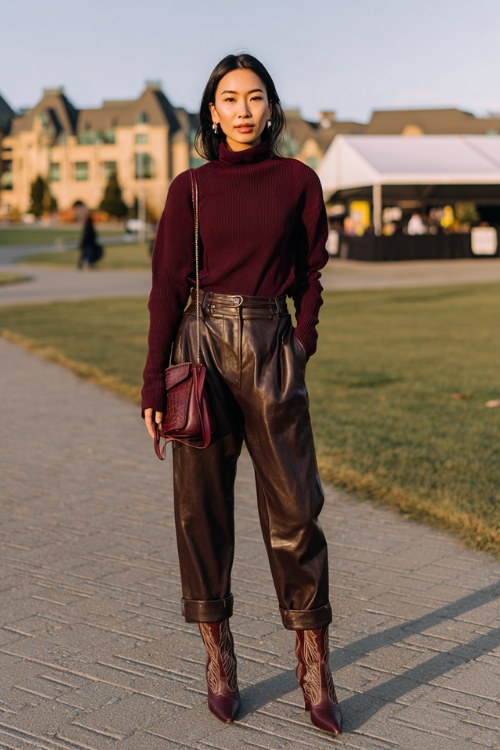 a woman in a deep burgundy oversized turtleneck tucked into high-waisted chocolate brown leather trousers, pointed dark brown cowboy boots (3)