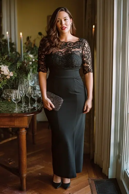 A plus-size woman wears a refined black crepe gown with lace bodice overlay and structured skirt, styled with pointed heels and statement clutch