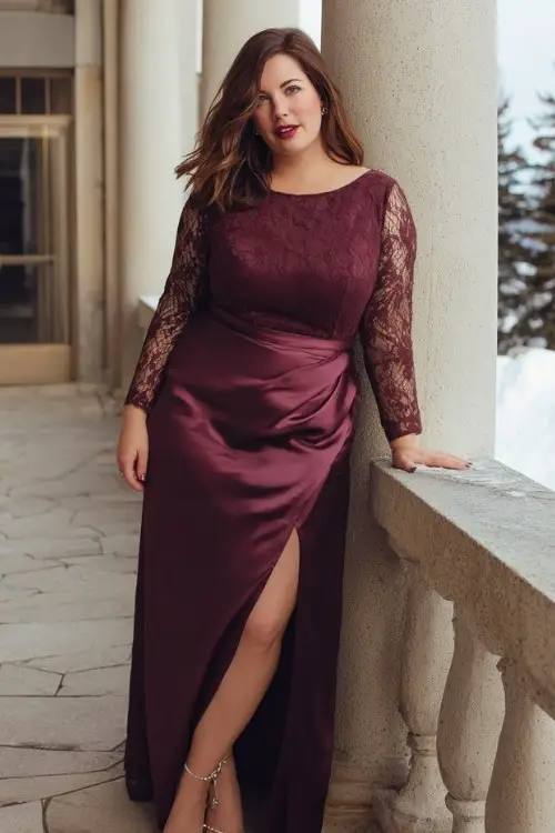 A plus-size woman wears a sophisticated burgundy satin gown with subtle train and lace sleeve accents, paired with refined heels and pearl jewelry
