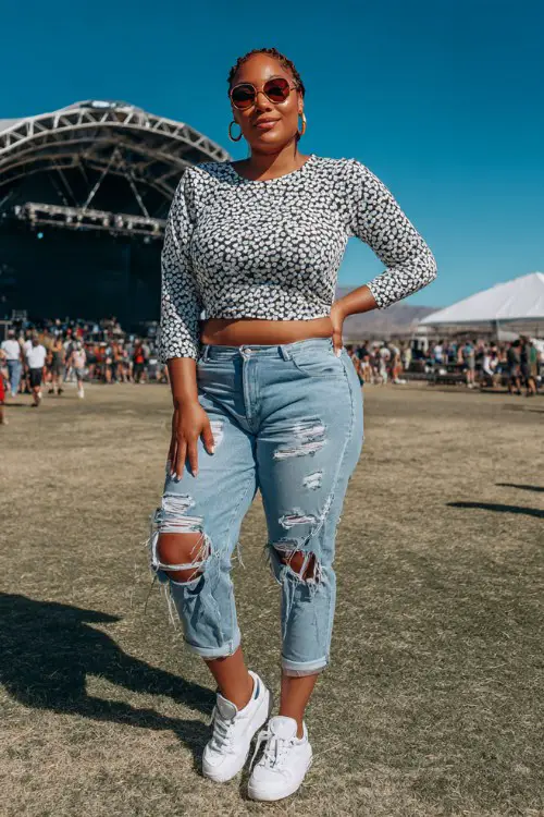 A curvy woman wears a fitted sequin heart-print top with high-waisted ripped jeans, white platform sneakers, and hoop earrings