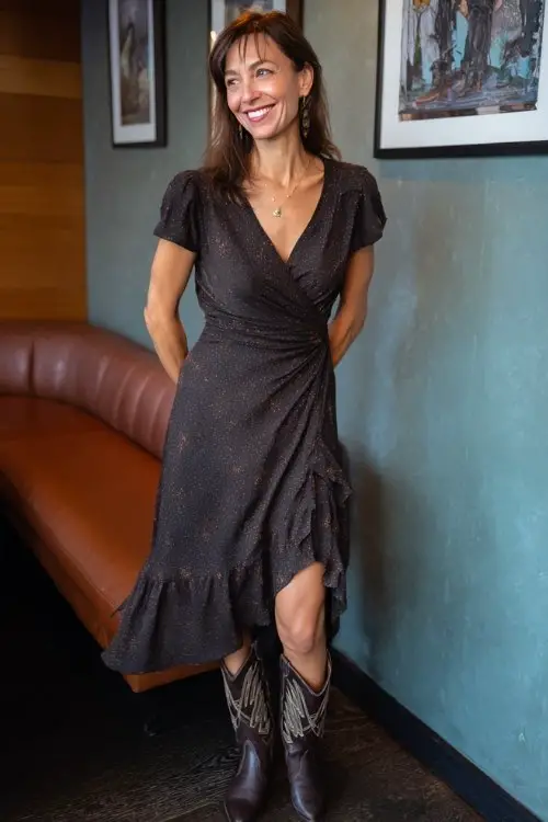 A woman over 40 wears a flowy wrap midi dress with subtle shimmer and vintage-style cowboy boots