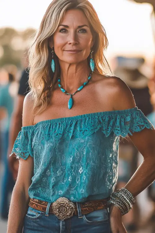 A woman over 40 in a rustic off-the-shoulder blouse tucked into high-rise bootcut jeans, styled with cowboy boots and turquoise jewelry at a country concert (2)