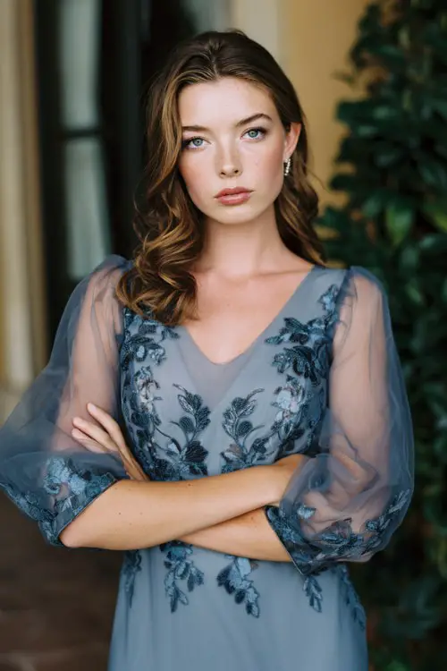 Curvy mature woman in steel blue embroidered organza dress, sheer sleeves, polished hairstyle