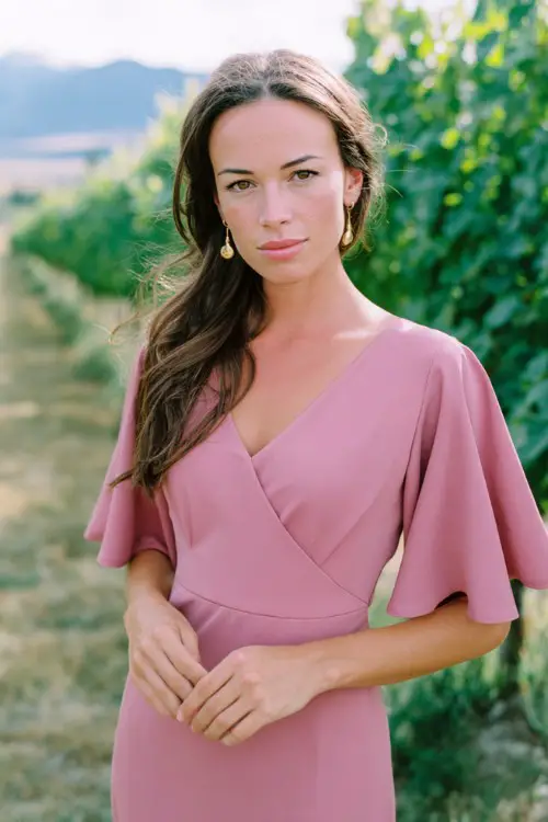 Woman over 40 wearing rosewood pink casual classy midi dress, flutter sleeves, comfortable refined styling