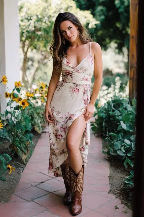 a woman wears a summer wedding guest dress with cowboy boots outfit