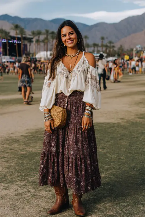 A curvy woman wears brown cowboy boots with a tiered bohemian maxi skirt and a loose embroidered blouse with billowy sleeves, accessorized with stacked bangles and a woven crossbody bag