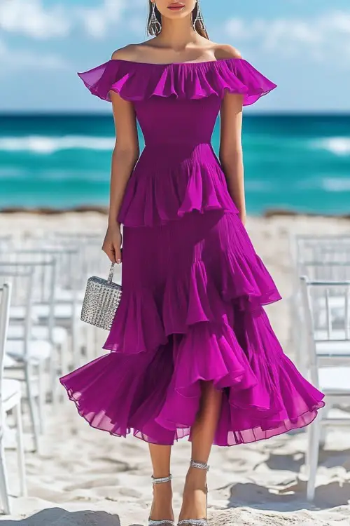 A stylish woman in a rich magenta tiered midi dress with cap sleeves and a flared skirt, accessorized with silver strappy heels and a matching clutch 
