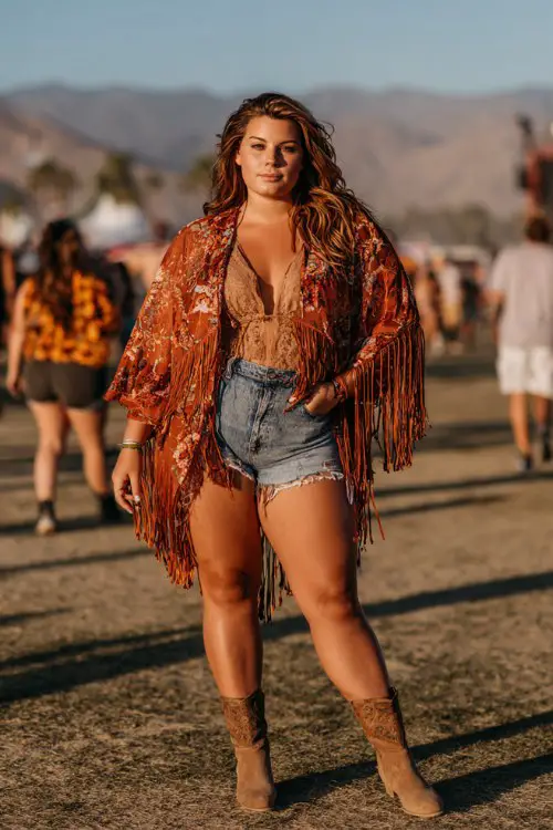 Woman in boho outfit with flower crown at Coachella festival.