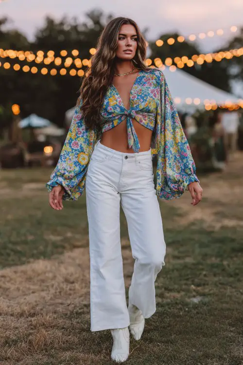 Fashion model wearing a boho floral long-sleeve tie-front crop blouse with flowy sleeves, high-waisted white jeans, paired with classic white cowboy boots