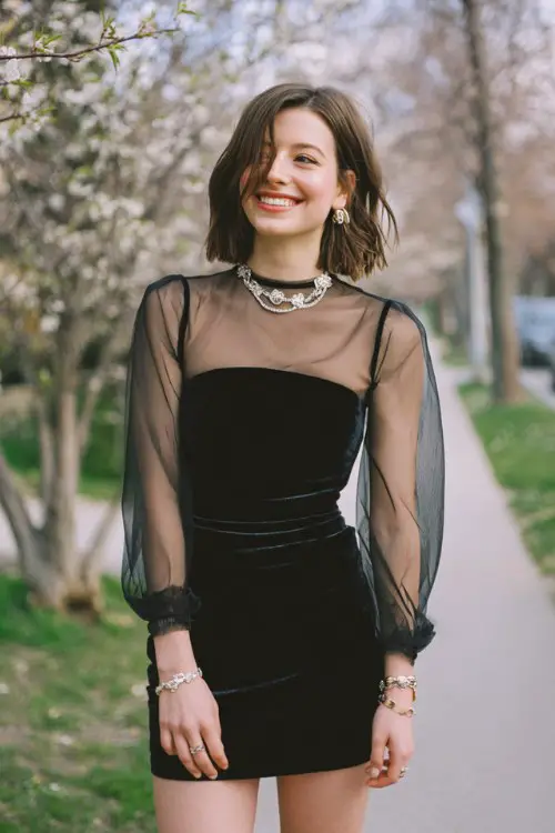 Modern rocker cocktail dress outfit for a spring wedding, black velvet mini dress with sheer sleeves