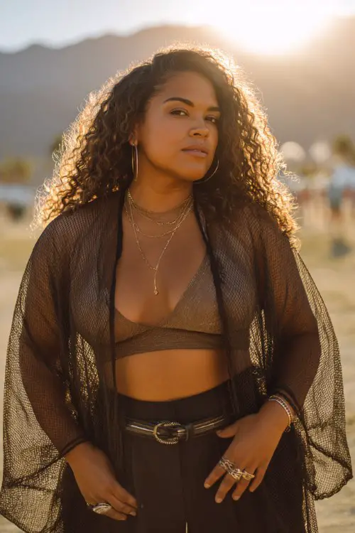 Plus size woman in sheer duster kimono, bralette, high-waisted flare pants, statement belt, chunky rings