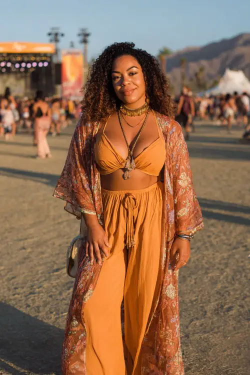 Plus size woman wearing a fitted bodysuit, sheer embroidered kimono, wide-leg flowy pants, leather sandals