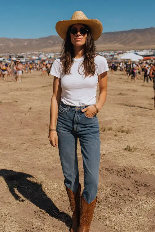 Woman in a simple white tee, high-waisted straight-leg jeans, brown cowboy boots, straw hat