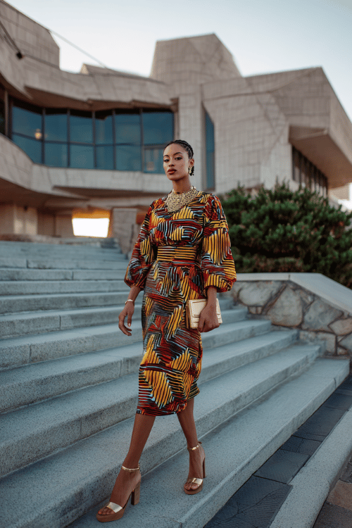 Bold geometric patterns in warm gold, rust, and charcoal tones turn this midi dress into a standout statement for gallery openings,