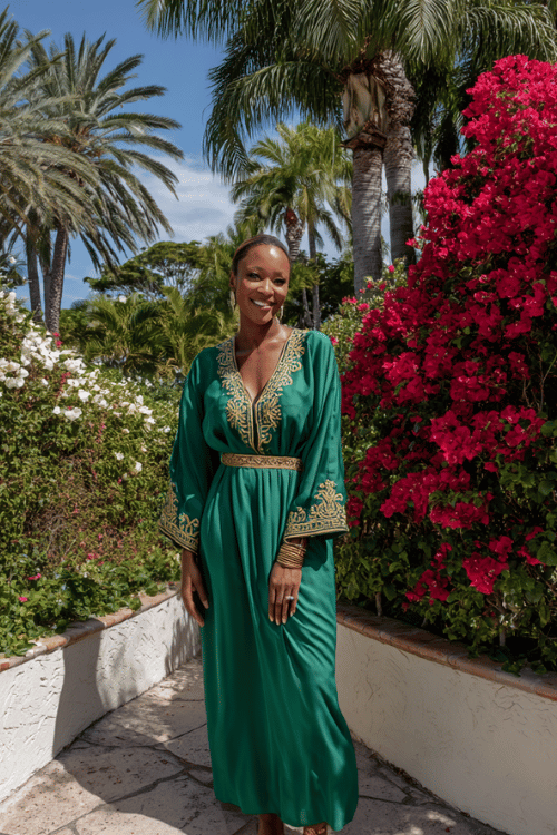 Emerald green kaftan-style maxi dress with intricate gold embroidery creates a luxurious vacation look that feels elegant