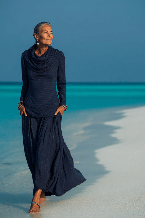woman in her 50s wearing a breathtaking long-sleeve maxi dress in deep ocean blue with subtle silver thread woven throughout the lightweight fabric