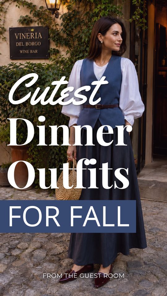 A woman wears a cute fall dinner outfit with a white puff-sleeve blouse, blue tailored vest, navy maxi skirt, burgundy flats, and a woven handbag