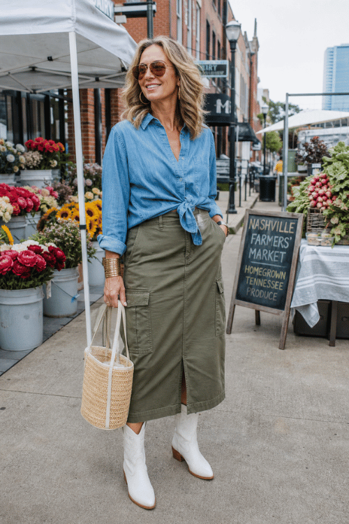 Woman wearing a chambray tie-front shirt, olive cargo midi skirt, and white cowboy boots at the Nashville Farmers' Market.
