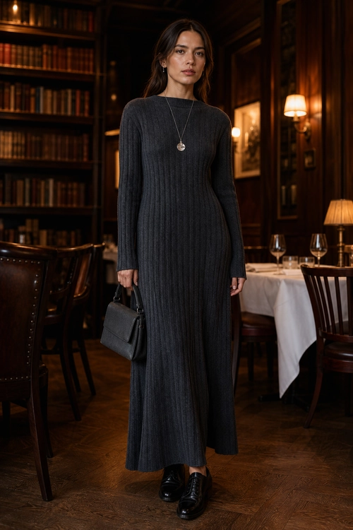Woman wearing a charcoal ribbed long-sleeve maxi dress with black shoes, a structured handbag, and a pendant necklace.