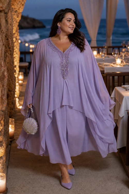 A woman wears a flowing lilac draped tunic with matching trousers, pointed pumps, drop earrings, and a beaded clutch.