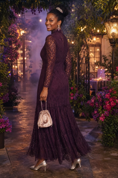 Plum Lace Evening Dress A woman wears a long plum lace dress with sheer sleeves, silver heels, and a satin drawstring handbag.